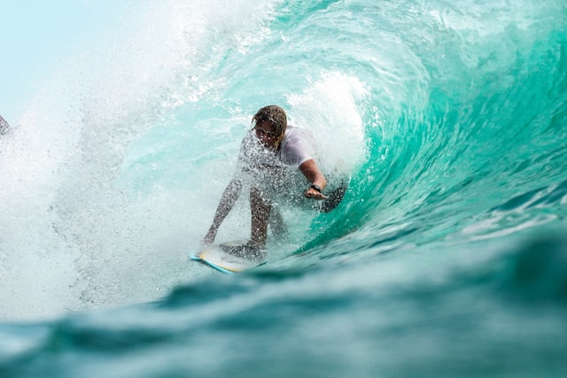 A surfer riding inside a breaking wave
